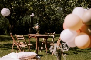 Tafeltje met vier stoelen in een grasveld met ballonnen op de voorgrond